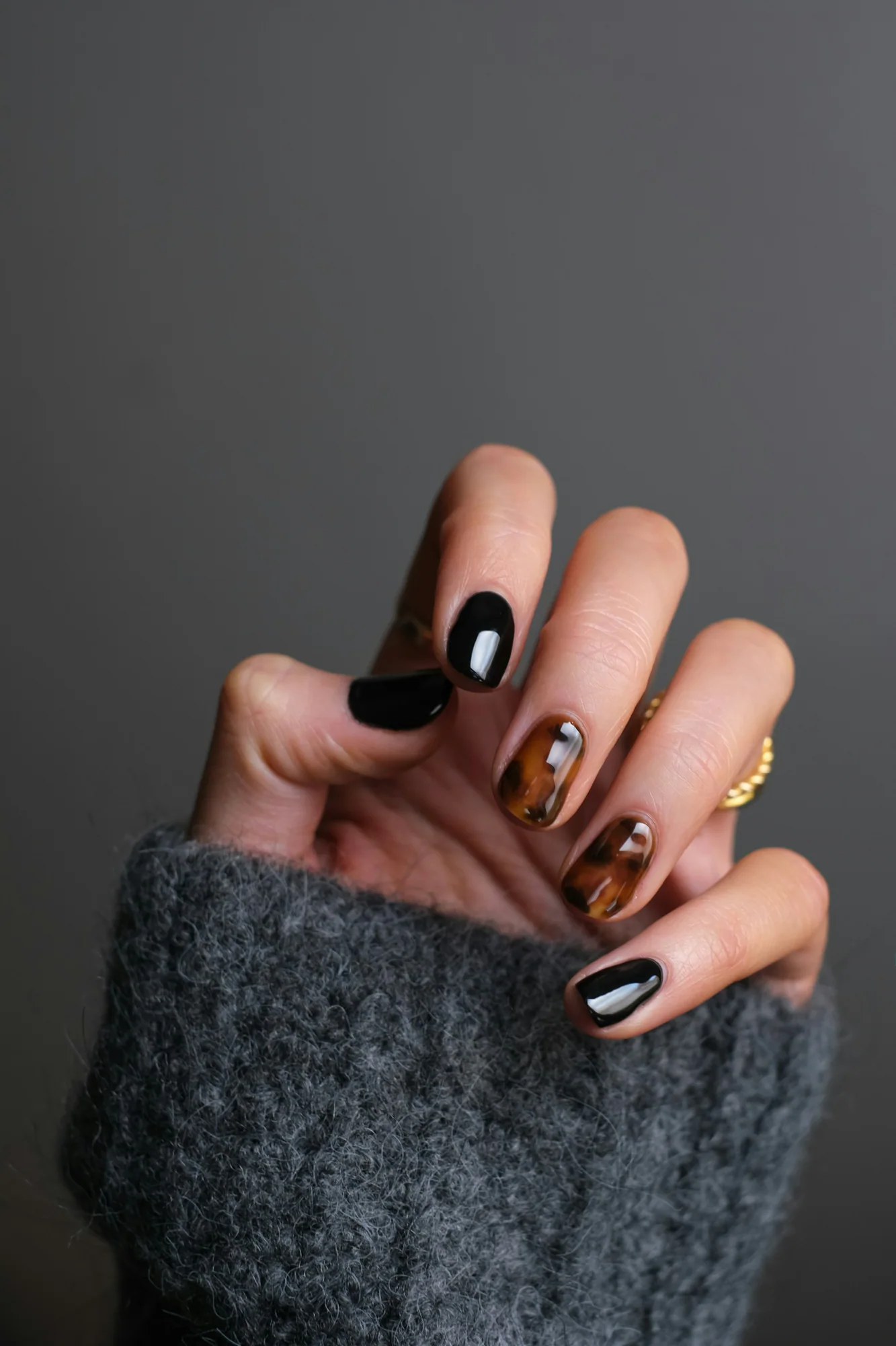 Manicured hands with black and nude nail art