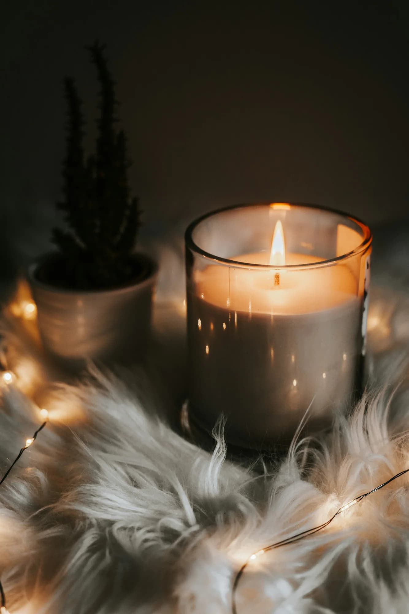 Lit candle in an amber glass jar
