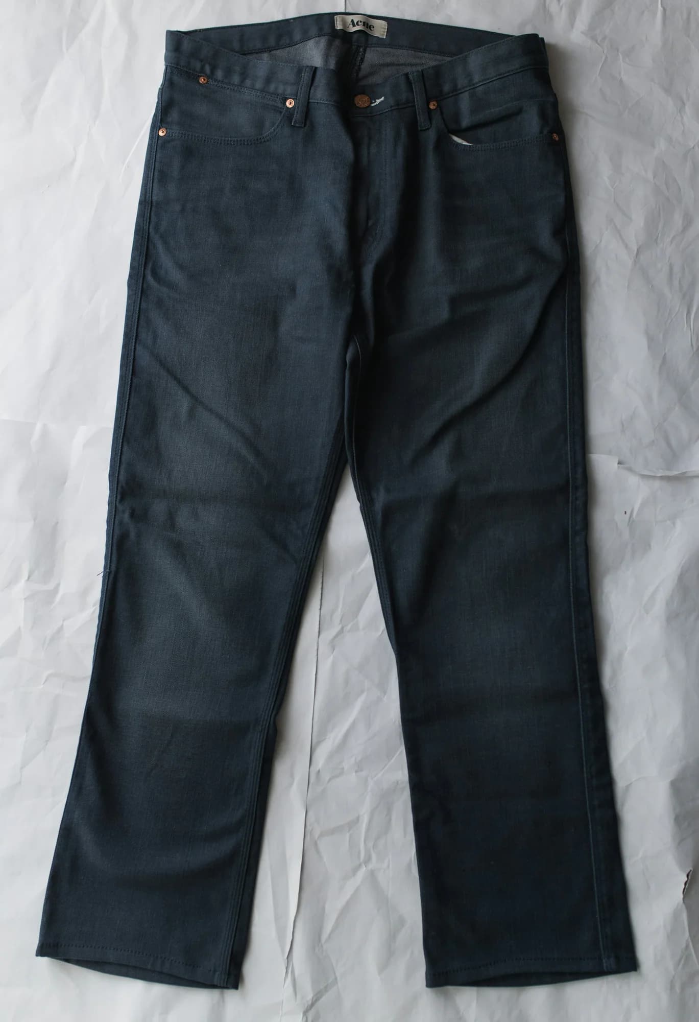 Dark raw denim jeans laid flat