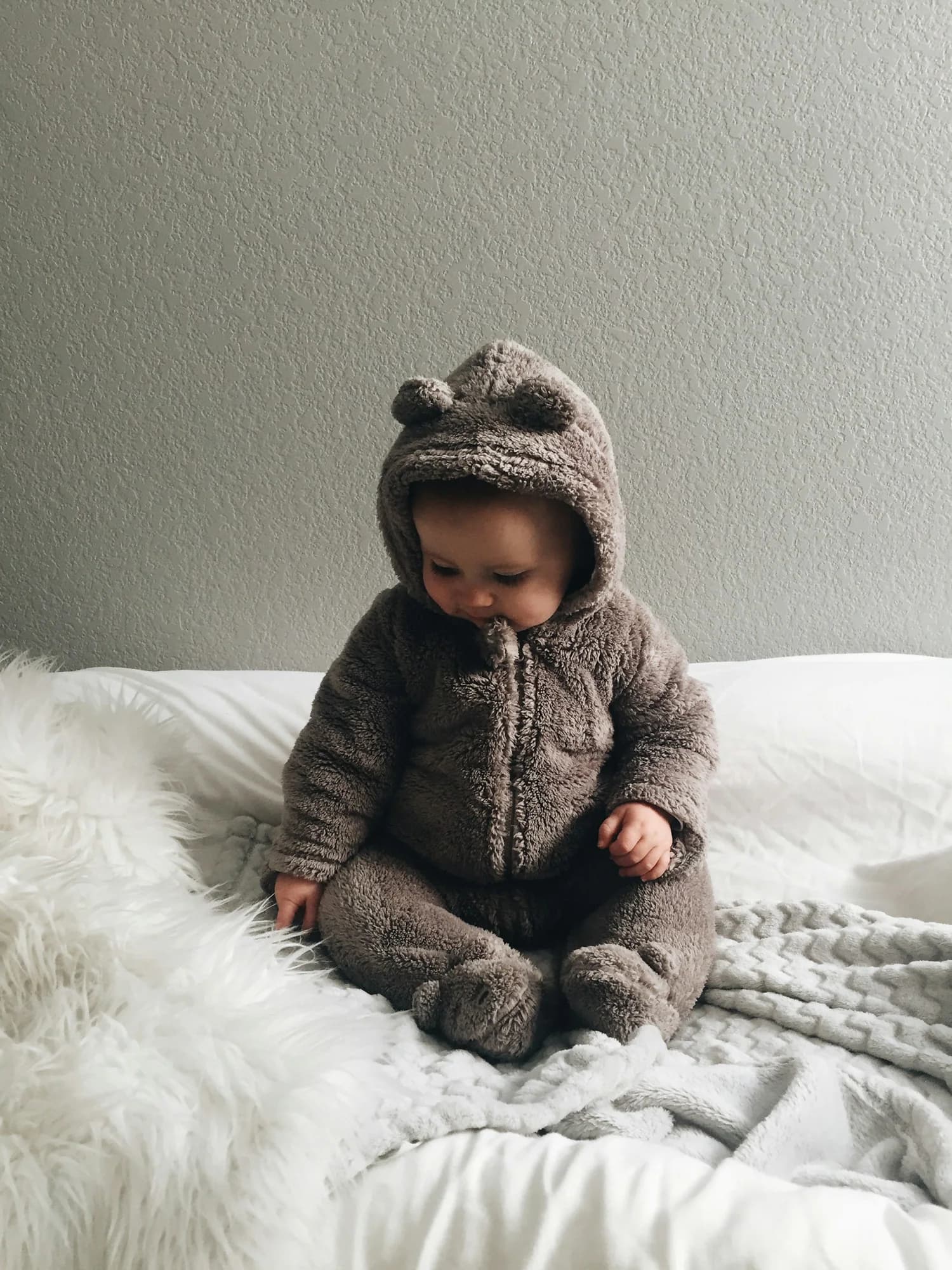 Baby wearing a brown bear-ear fleece onesie