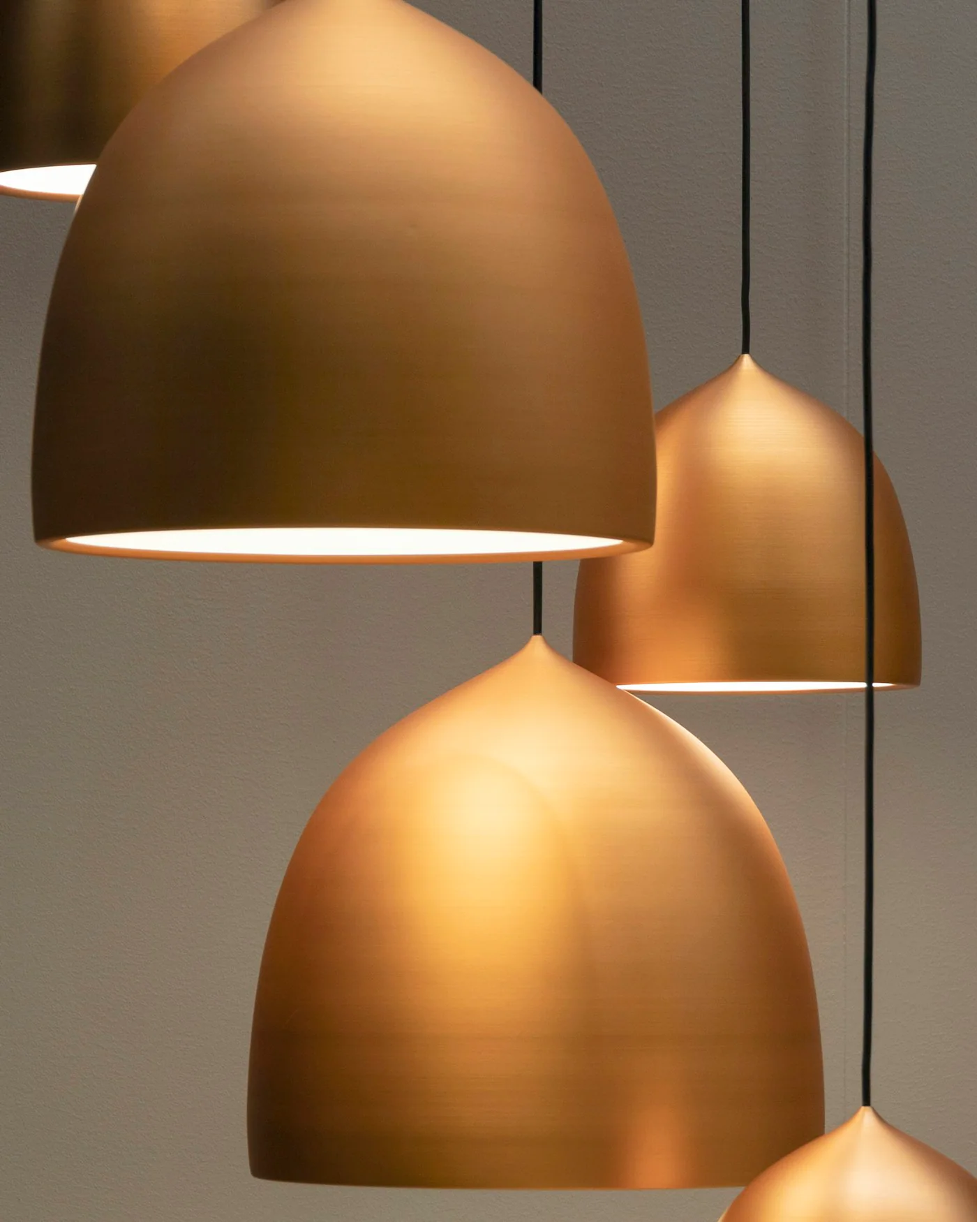 Three brass bell pendant lights hanging — detail