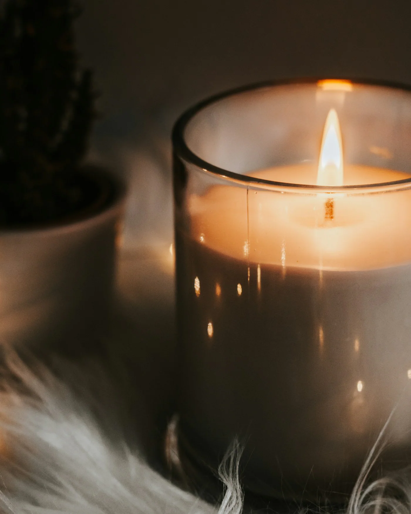 Lit candle in an amber glass jar — detail