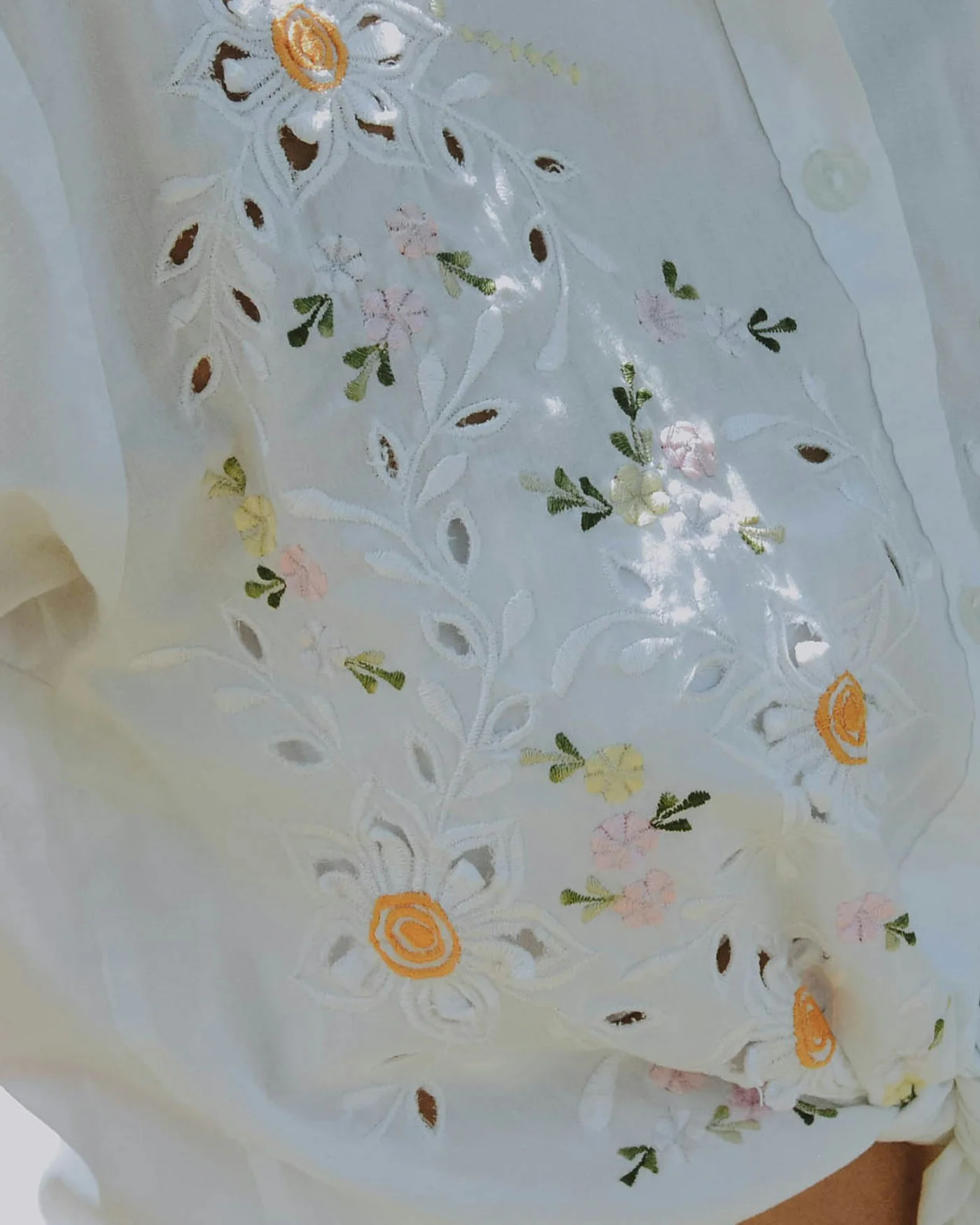 Close-up of a white blouse with floral embroidery — detail