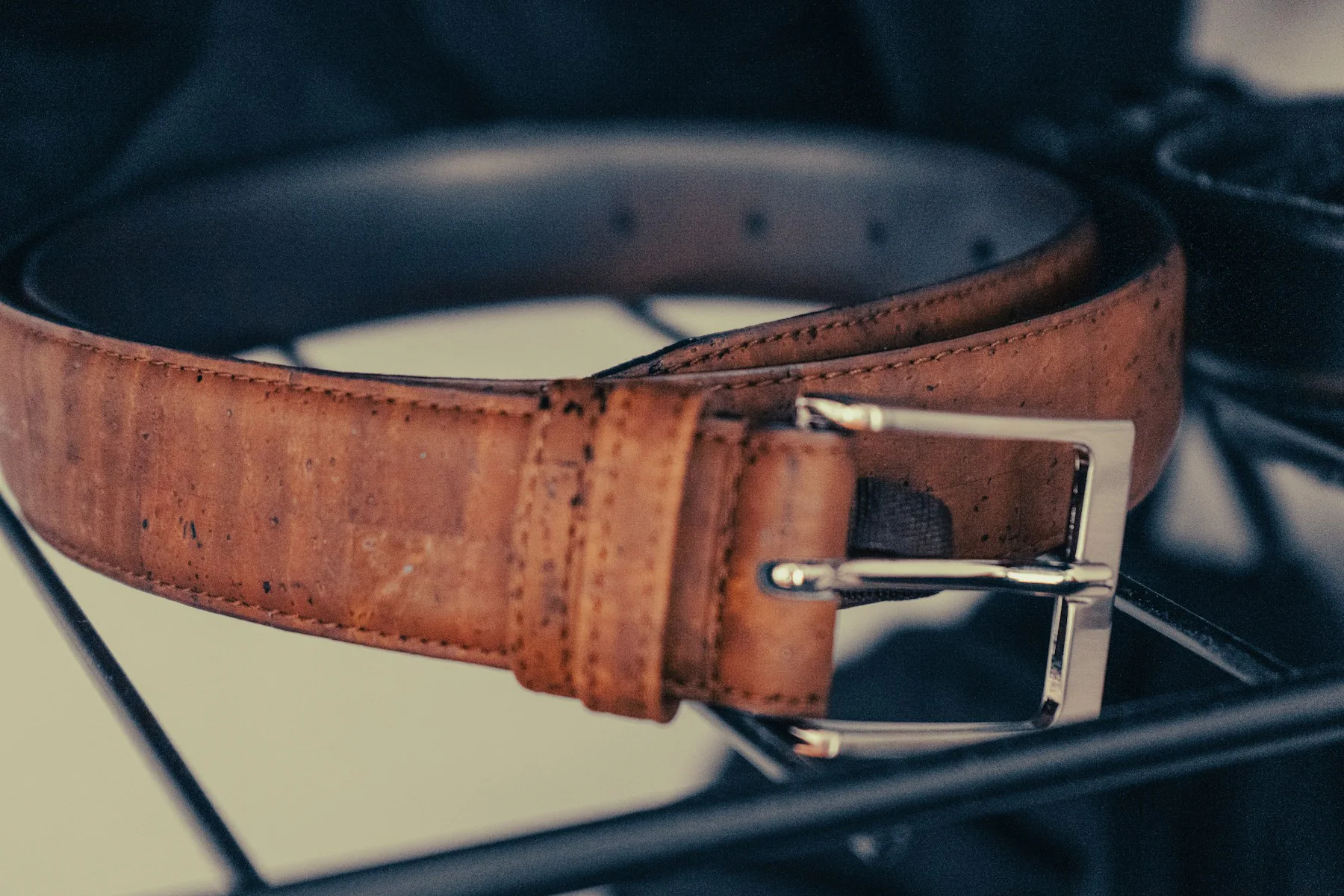 Close-up of a brown leather belt with a metal buckle