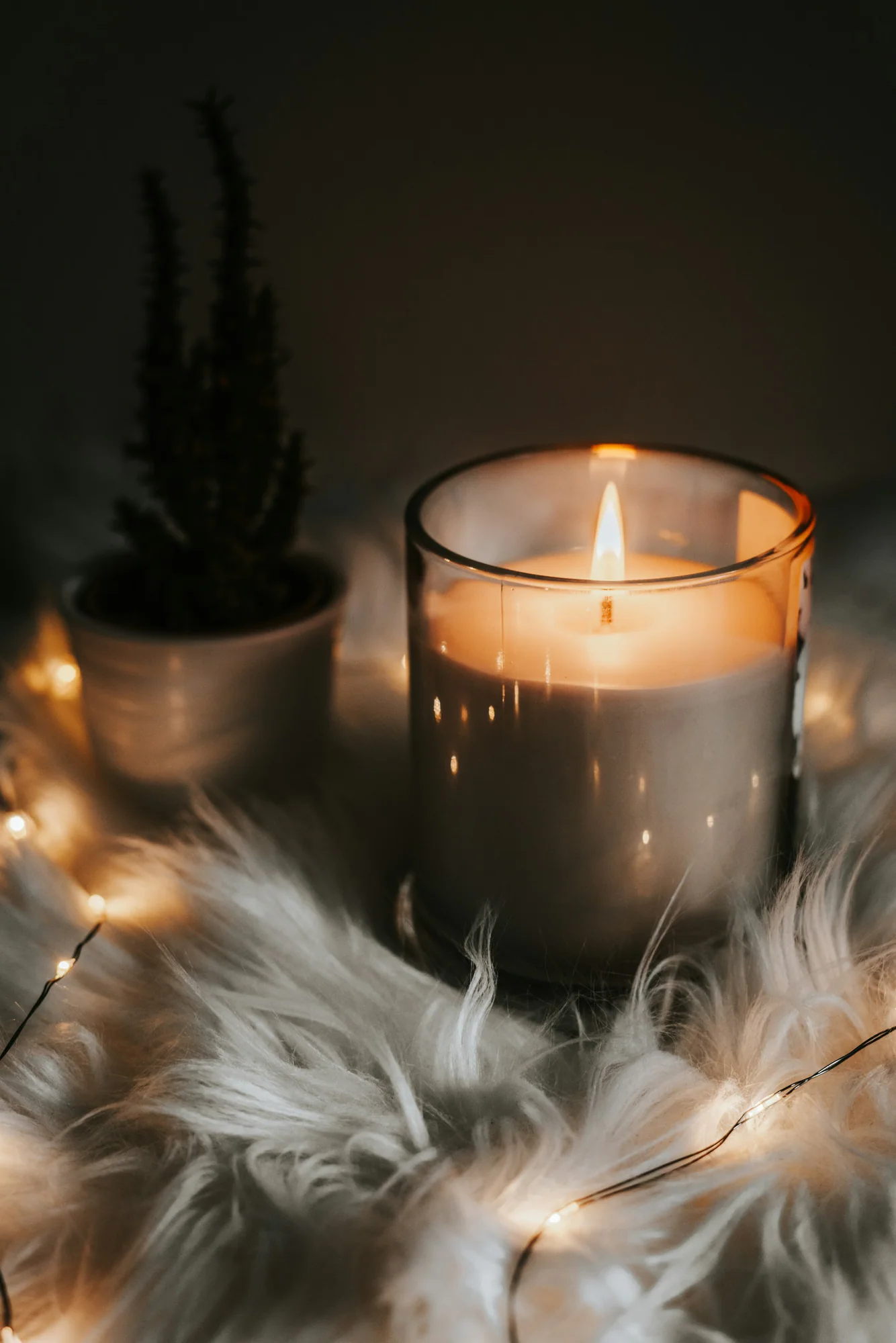 Lit candle in an amber glass jar