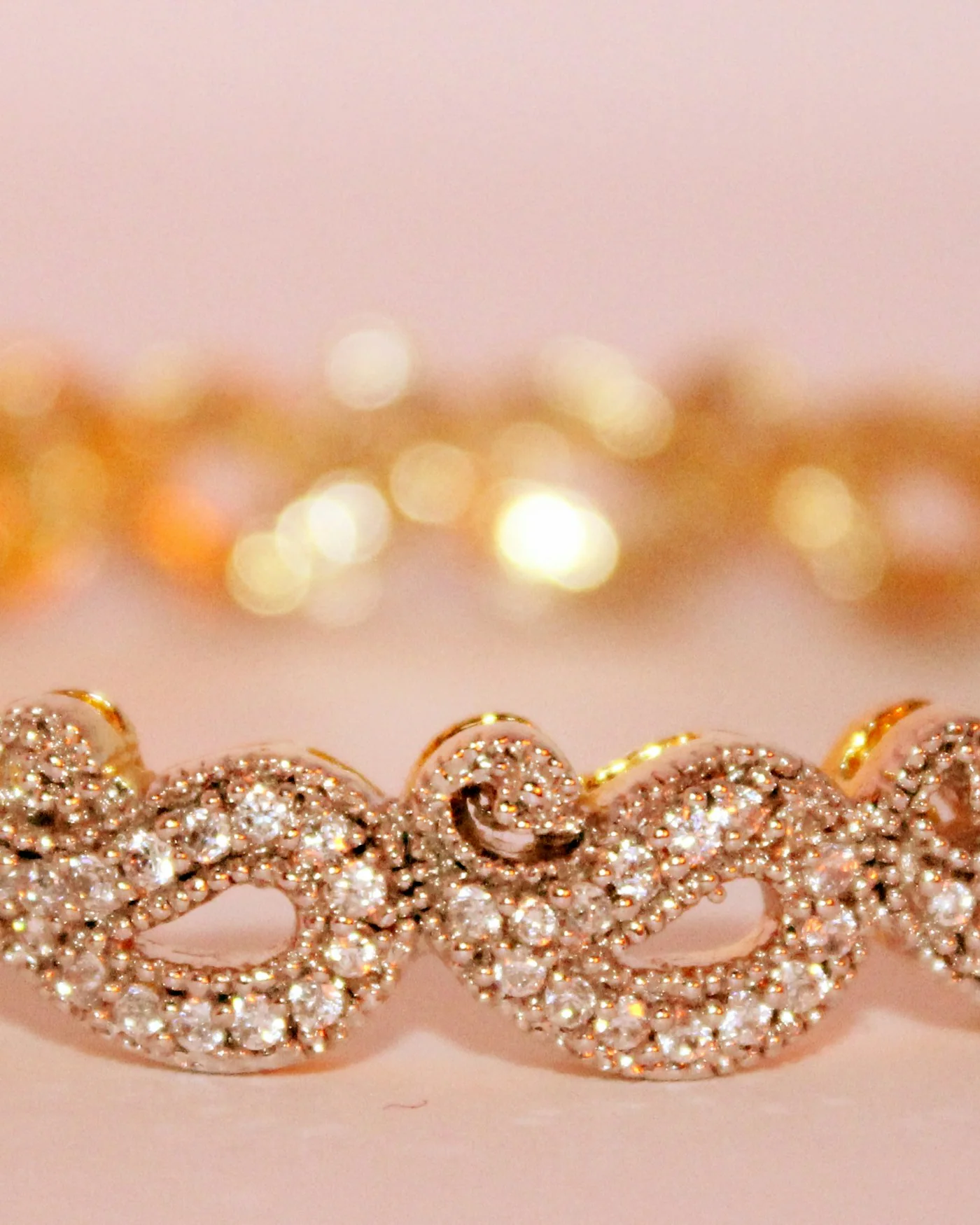 Rose gold pavé bangle on a pink background — detail