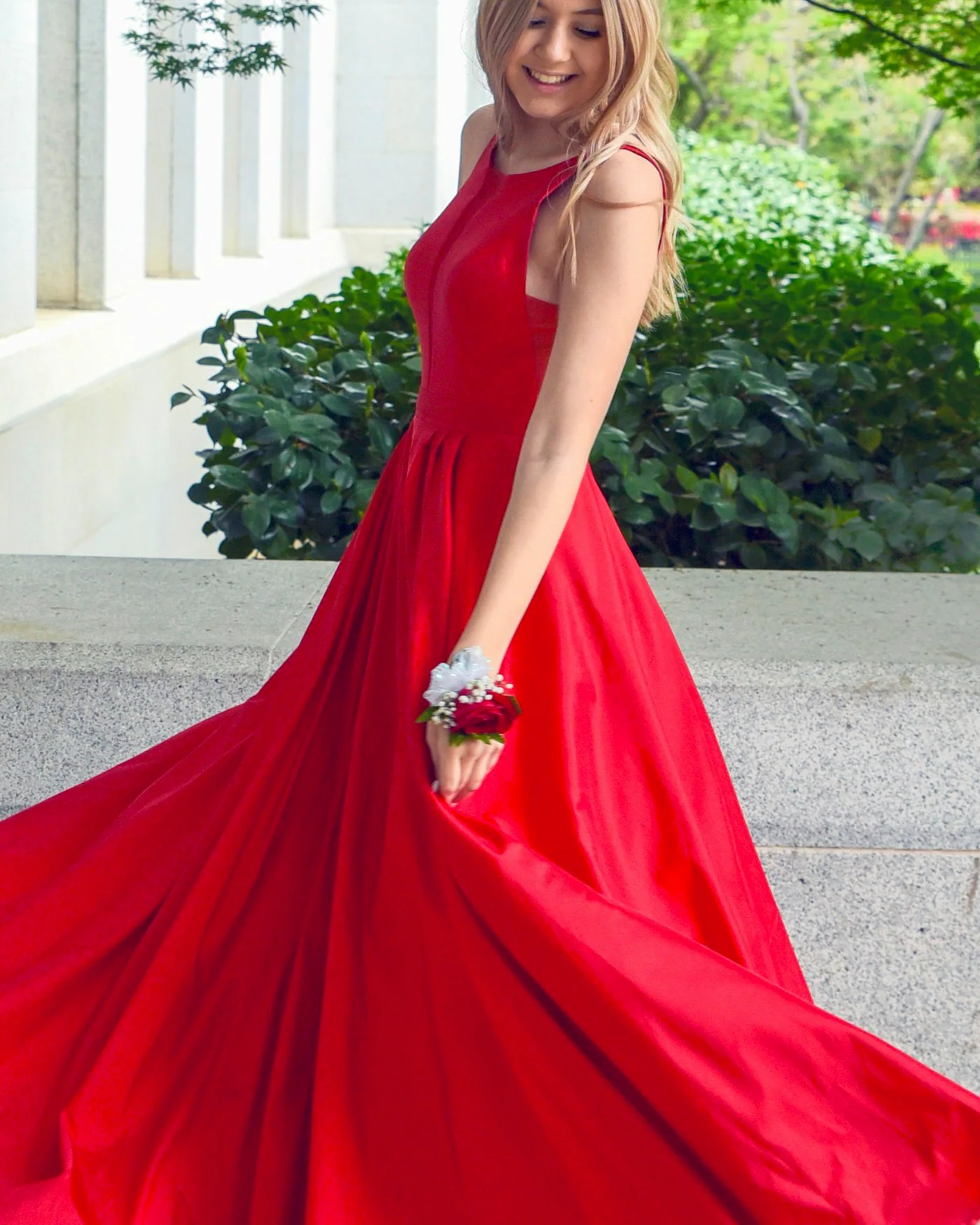 Woman in a flowing red silk gown outdoors — detail