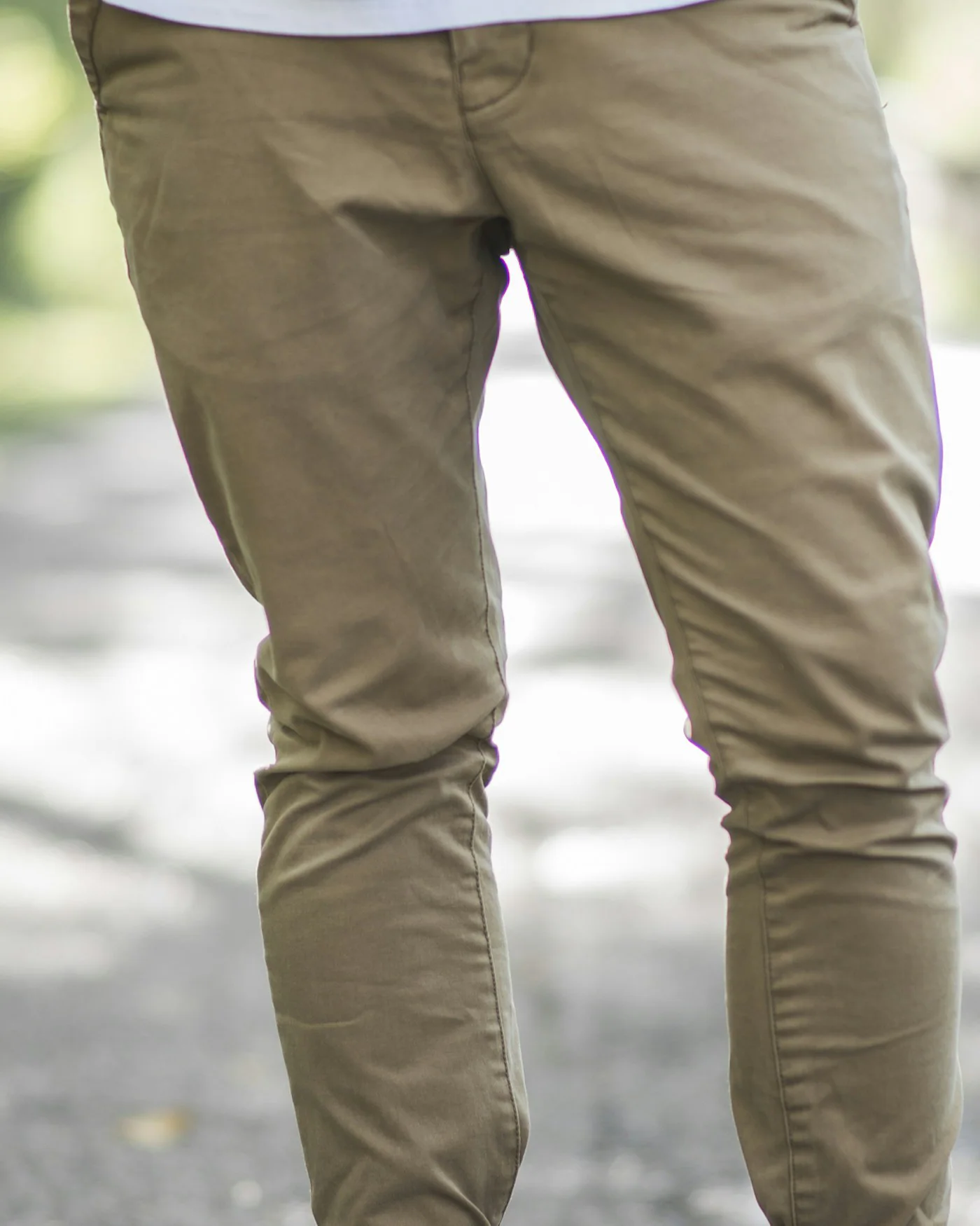 Man wearing khaki tapered chinos and white sneakers — detail