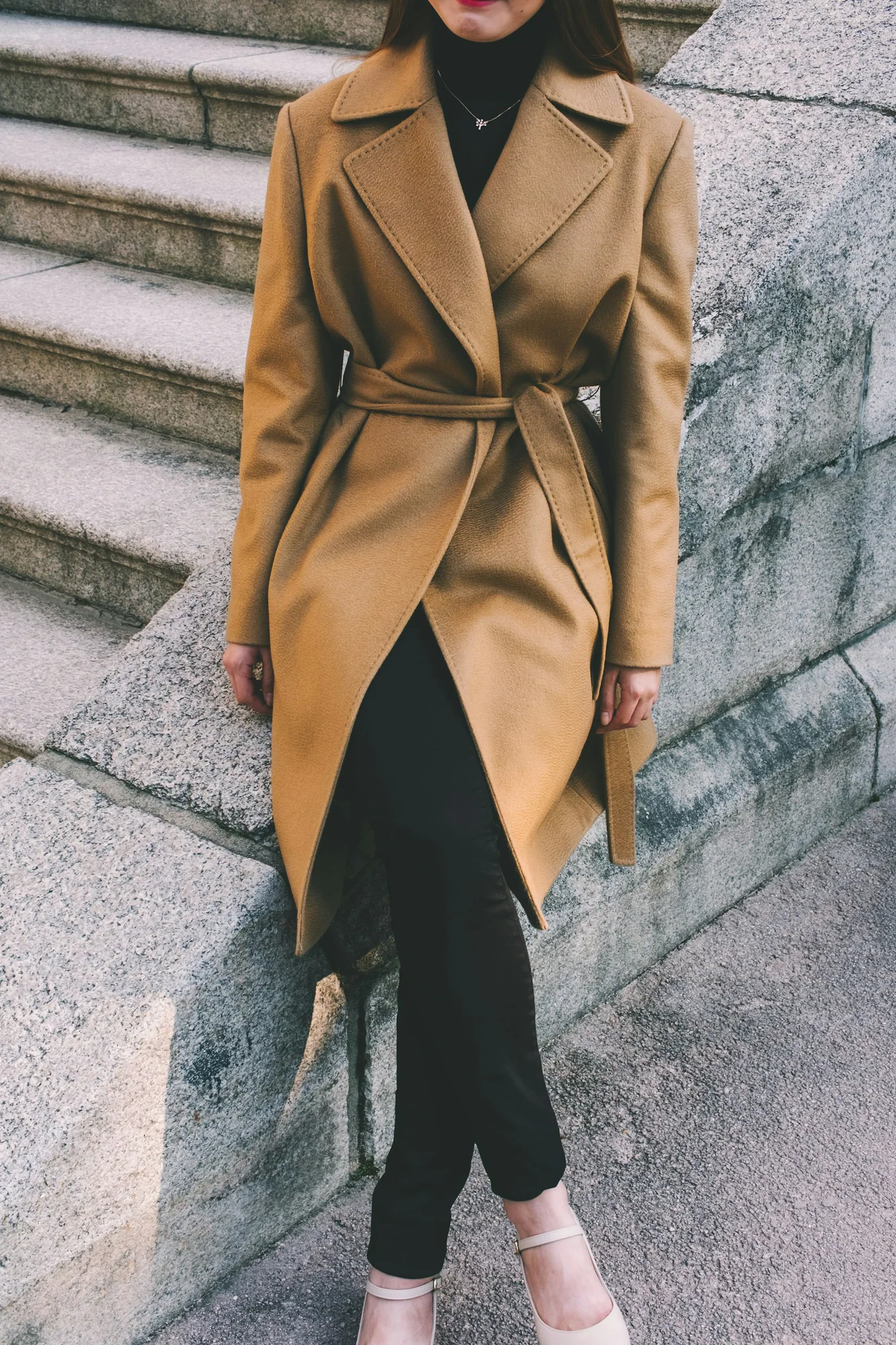 Person wearing a belted camel trench coat