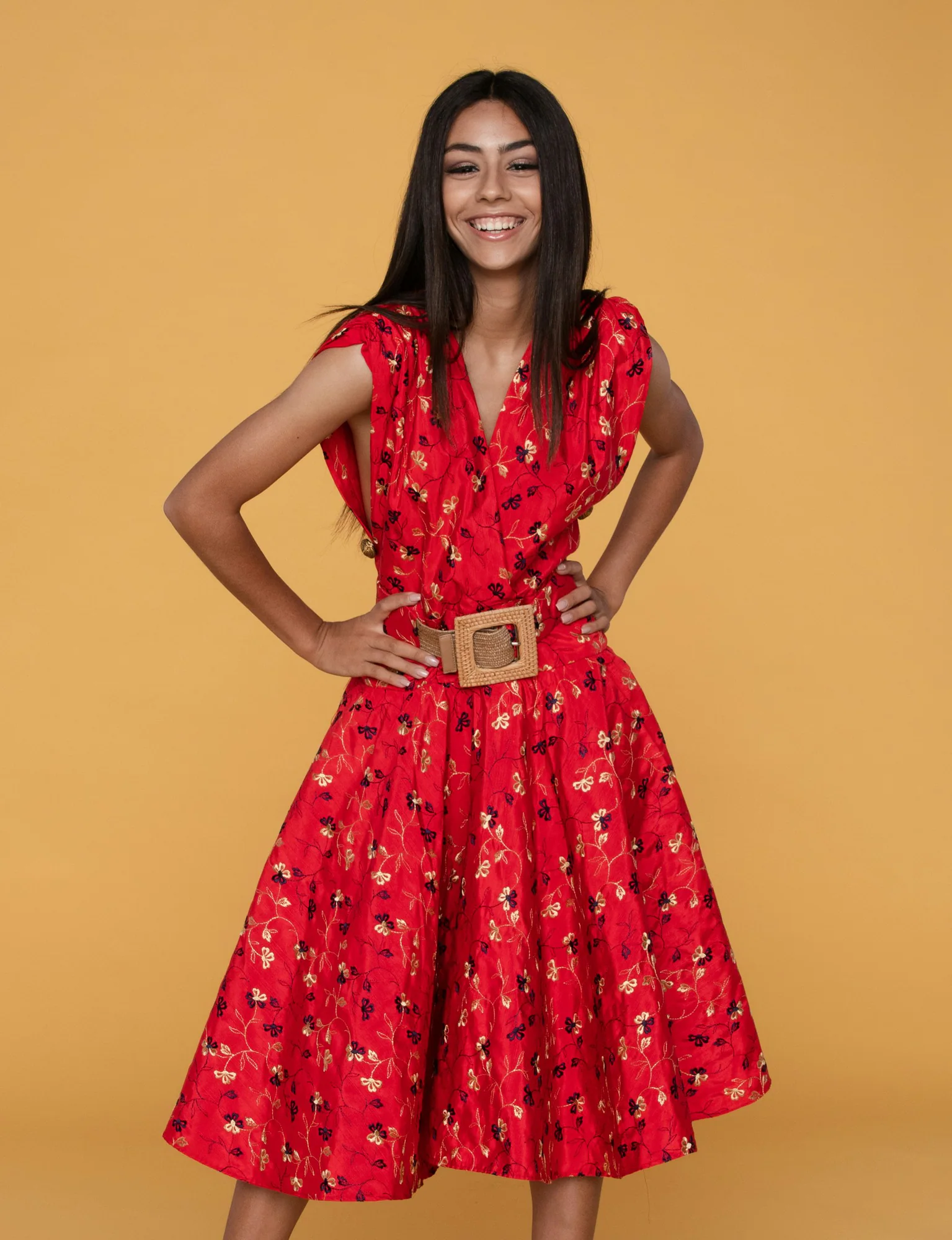 Smiling woman wearing a red belted midi dress