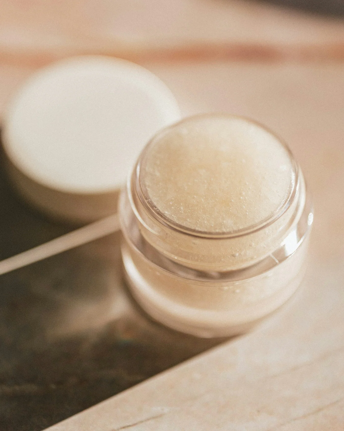 Open jar of rich face cream in soft light — detail