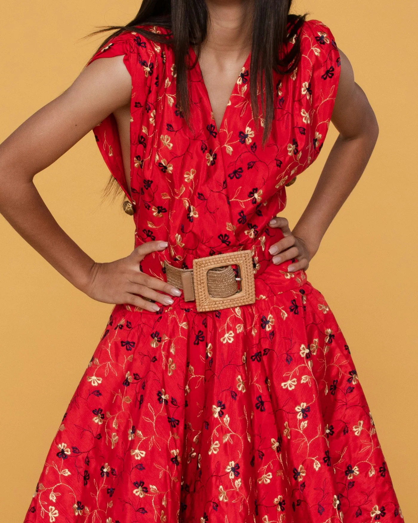 Smiling woman wearing a red belted midi dress — detail