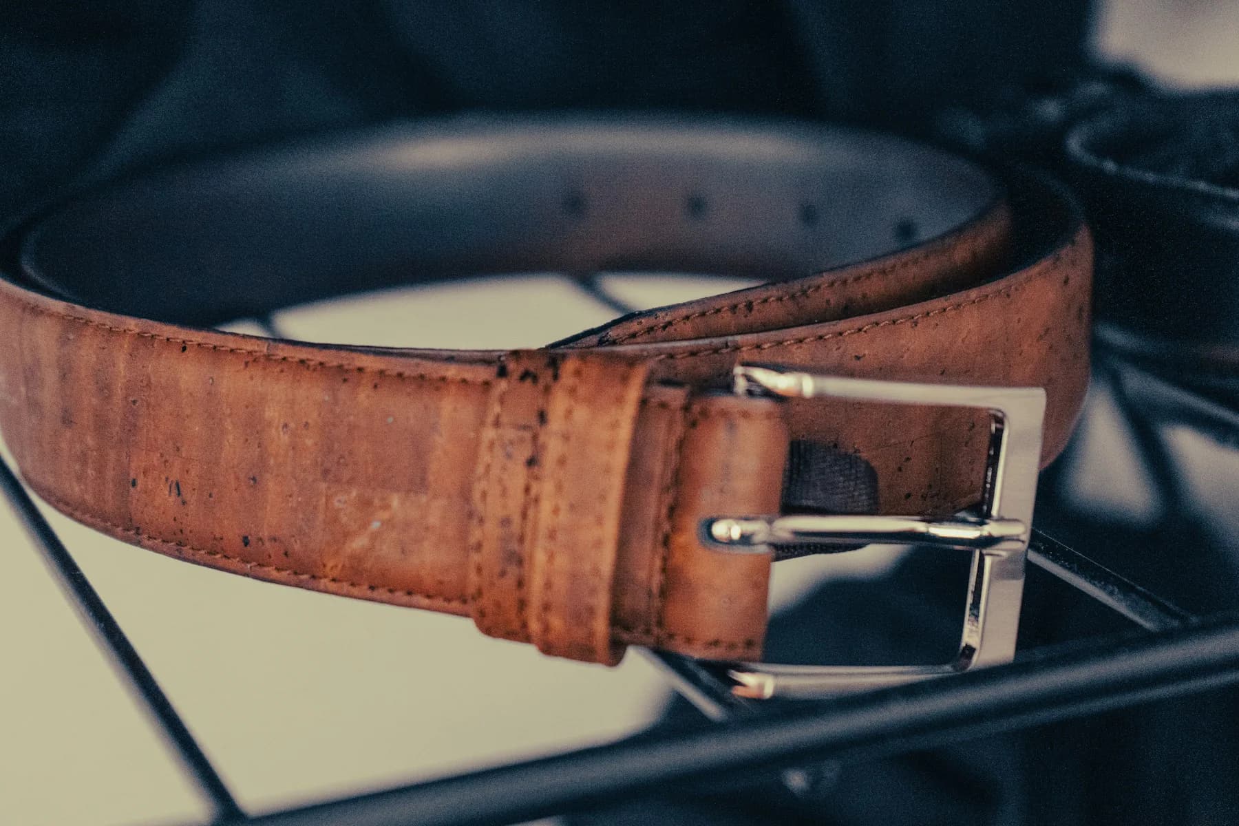 Close-up of a brown leather belt with a metal buckle