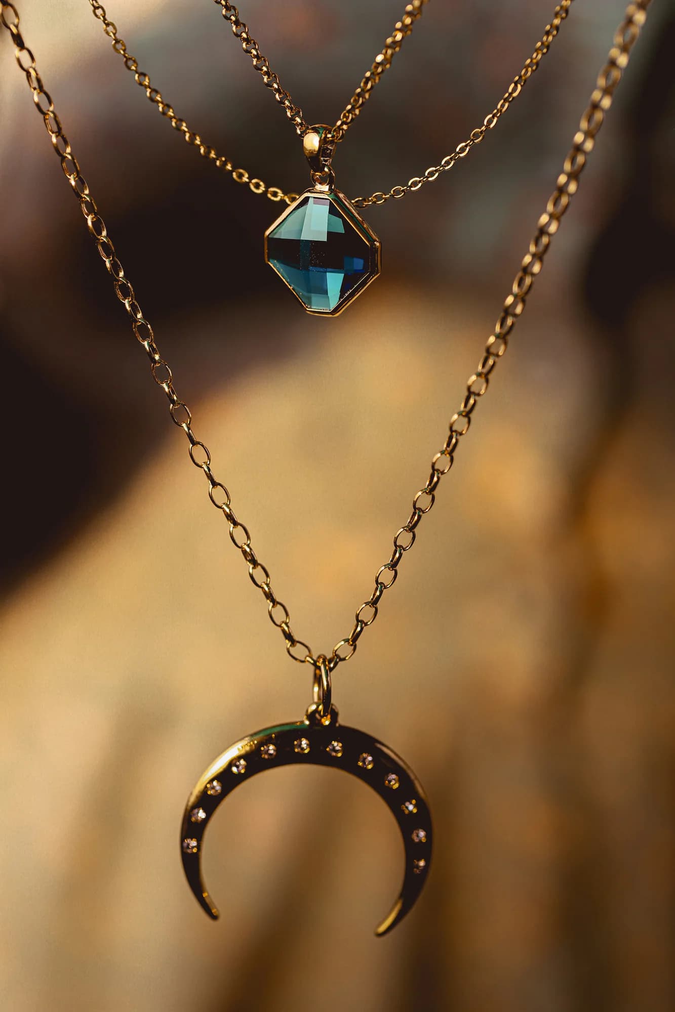 Gold pendant necklace with a blue stone