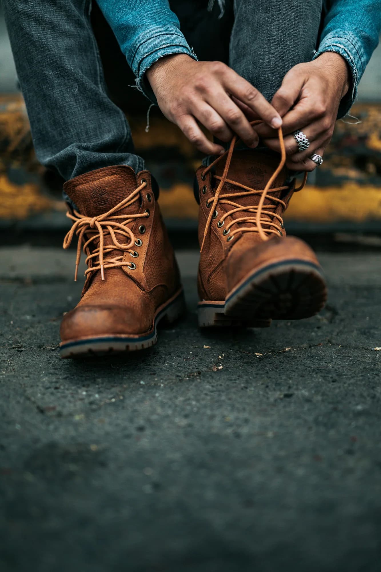 Person lacing brown leather work boots